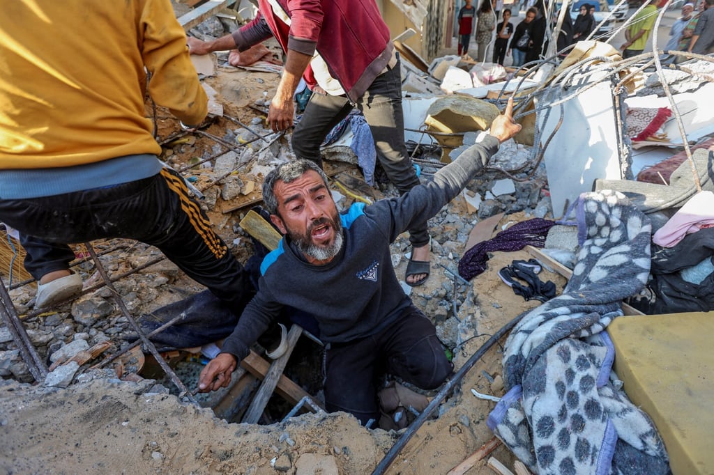 A Palestinian man searches for casualties at the site of an Israeli strike on a house in Nuseirat refugee camp in the central Gaza Strip. Photo: Reuters
