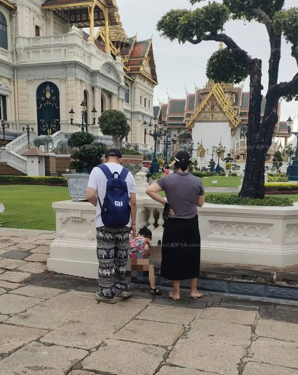 The little girl is watched by her parents as she relieves herself inside the palace compound. Photo: Siambird The little girl is watched by her parents as she relieves herself inside the palace compound. Photo: Siambird