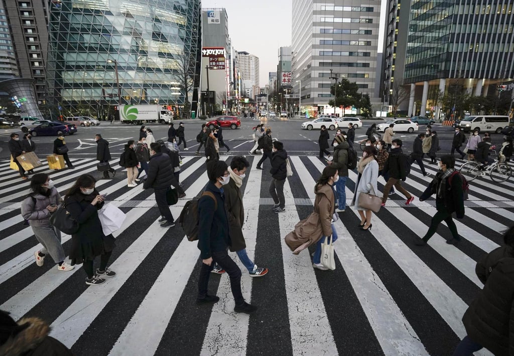 People wearing face masks walk in Nagoya, Japan, during the Covid-19 outbreak in February 2021. Photo: Kyodo