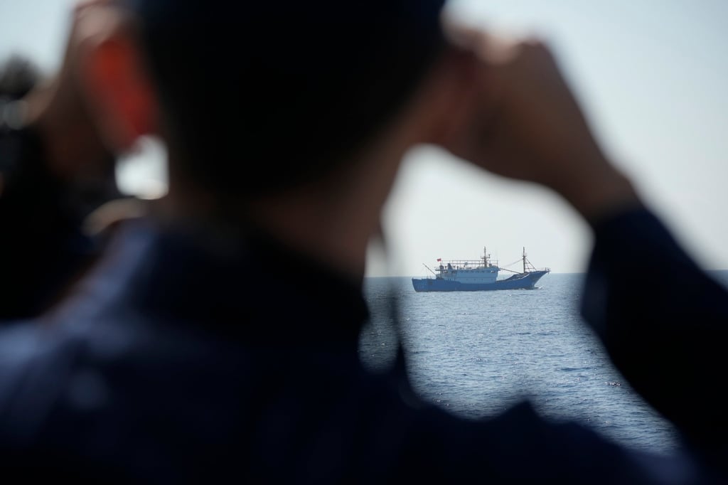 A Philippine coastguard personnel uses binoculars to monitor movements of suspected Chinese militia ships near Pag-asa island. Photo: AP A Philippine coastguard personnel uses binoculars to monitor movements of suspected Chinese militia ships near Pag-asa island. Photo: AP