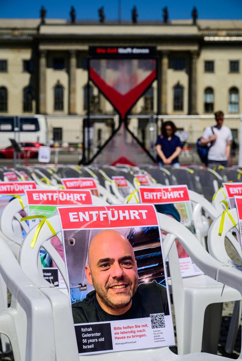 Portraits of Israeli hostages, including Itzhak Gelerenter (front), are fixed to chairs in front of a giant hour glass at an installation at Berlin’s Bebelplatz on Friday. Photo: AFP Portraits of Israeli hostages, including Itzhak Gelerenter (front), are fixed to chairs in front of a giant hour glass at an installation at Berlin’s Bebelplatz on Friday. Photo: AFP
