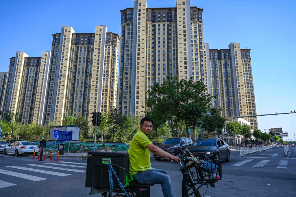 A man rides a scooter past a residential compound in Beijing on May 17, 2024. Photo: AFP A man rides a scooter past a residential compound in Beijing on May 17, 2024. Photo: AFP