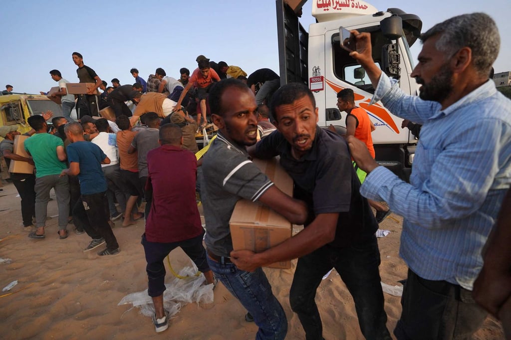 Palestinians loot a truck for humanitarian aid. Photo: AFP