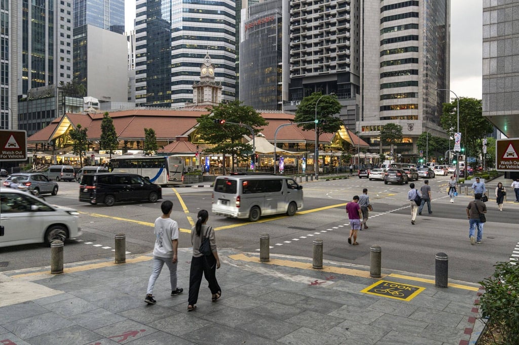 Pedestrians crossing a street in Singapore’s financial district. Photo: Bloomberg Pedestrians crossing a street in Singapore’s financial district. Photo: Bloomberg