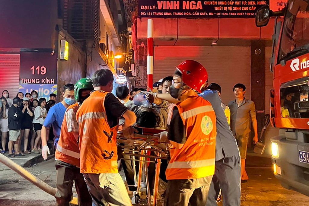 Workers carry a victim to an ambulance following a building in Hanoi, Vietnam on Friday. Photo: AFP Workers carry a victim to an ambulance following a building in Hanoi, Vietnam on Friday. Photo: AFP