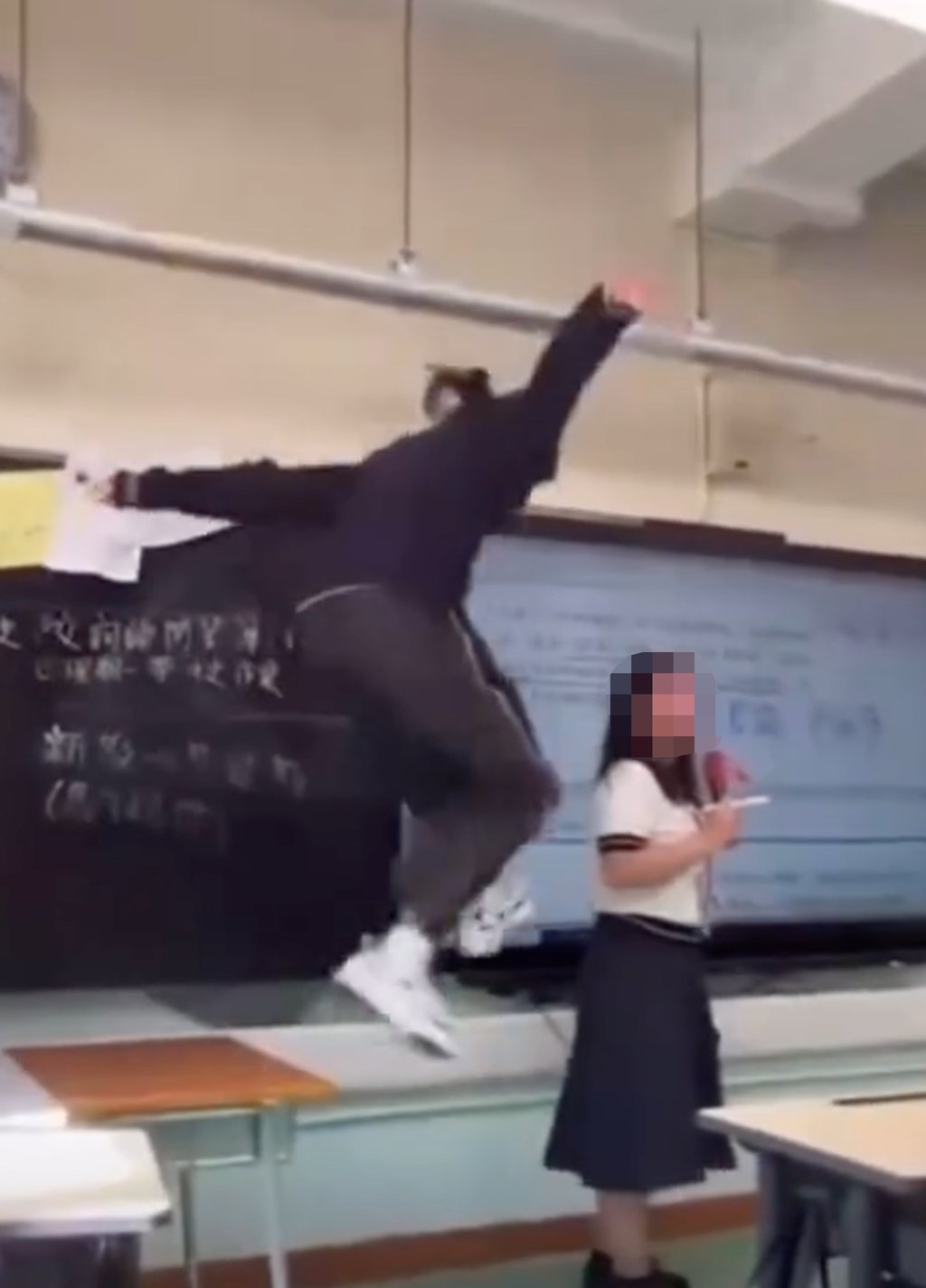 The student kicks a table and dances on it while the national anthem plays in the background. Photo: Xiaohongshu The student kicks a table and dances on it while the national anthem plays in the background. Photo: Xiaohongshu