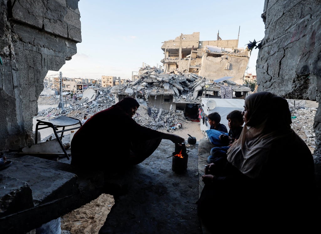 Palestinians sit at their house on Wednesday, after it was destroyed in an Israeli strike in Khan Younis, in the southern Gaza Strip. Photo: Reuters
