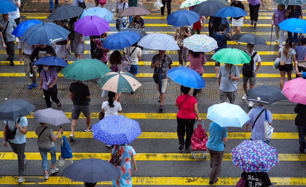 Pedestrians brave the rain in Sheung Shui on Monday morning. Photo: Eugene Lee