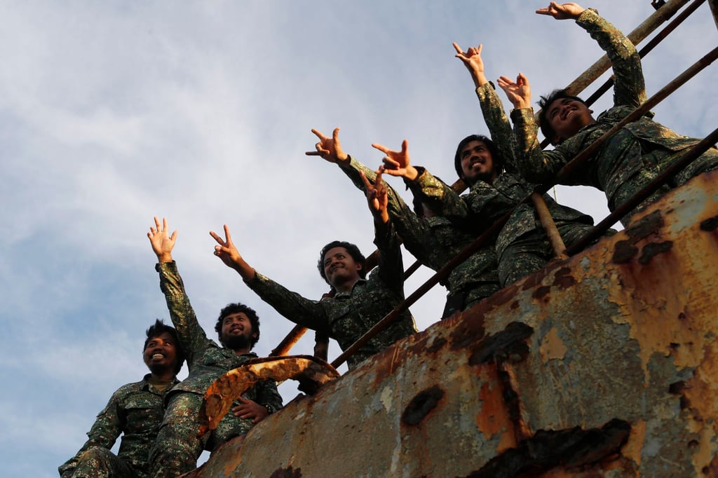 Philippine Marine Corps servicemen stationed aboard the BRP Sierra Madre at the disputed Second Thomas Shoal in the South China Sea gesture to reporters in 2014. Photo: Reuters Philippine Marine Corps servicemen stationed aboard the BRP Sierra Madre at the disputed Second Thomas Shoal in the South China Sea gesture to reporters in 2014. Photo: Reuters
