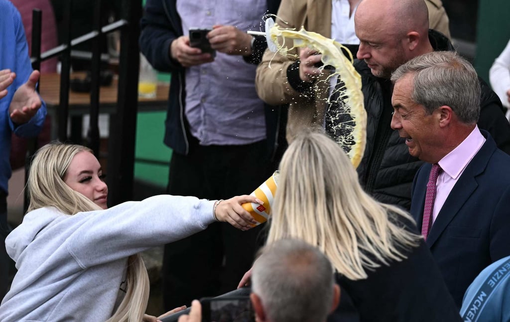 A woman throws a milkshake at Nigel Farage. Photo: AFP A woman throws a milkshake at Nigel Farage. Photo: AFP