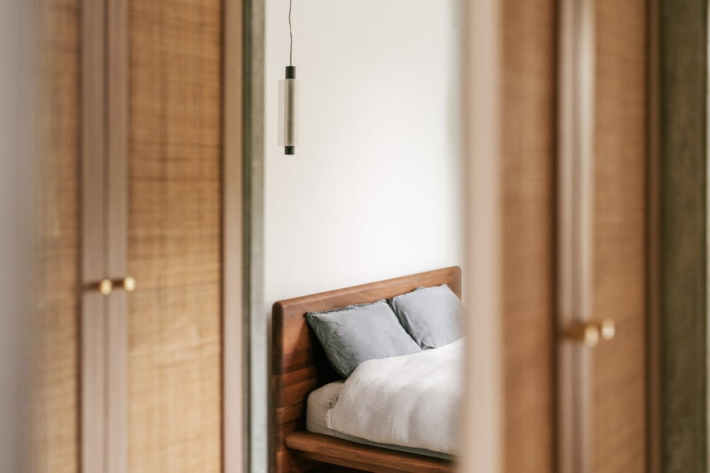 Above the bed hangs a Metropol pendant from Rakumba, designed by Sebastian Herkner. Photo: Common Studio