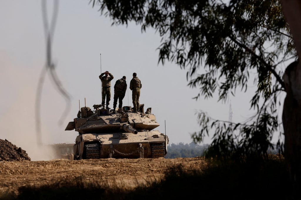 Israeli soldiers stand on top of a tank near the Israel-Gaza border. Photo: Reuters