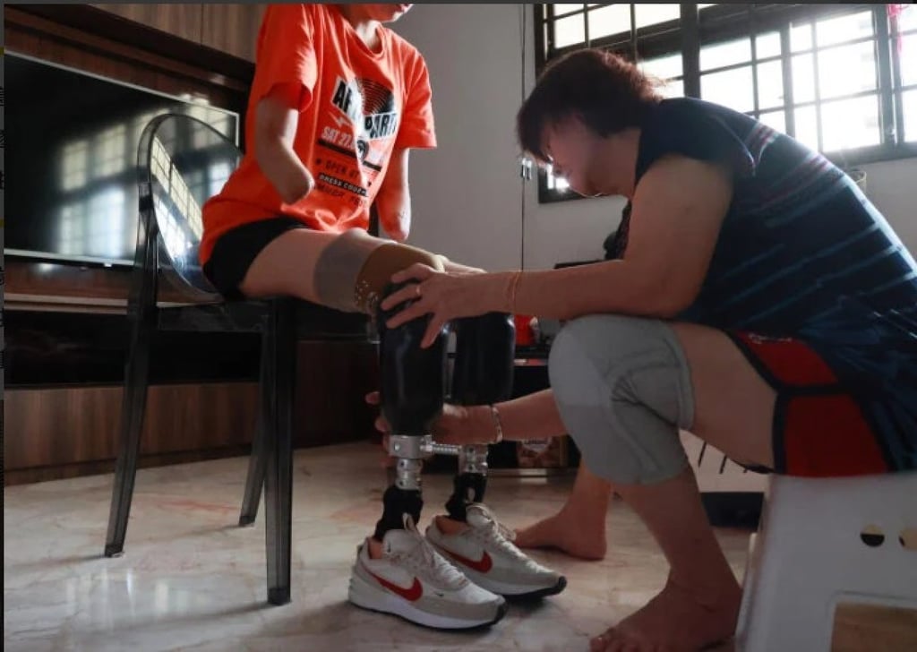 Lin’s mother helps her fit her prosthetic legs. Family and friends gave her the strength to carry on. Photo: Lin Ailing