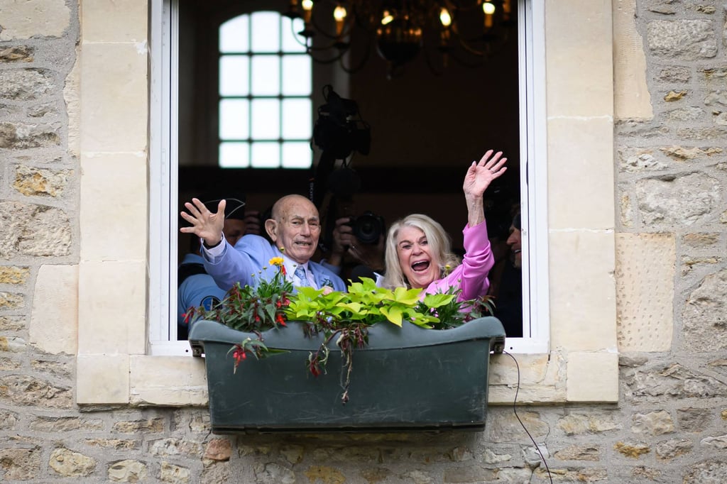 Newlyweds Jeanne Swerlin and US WWII veteran Harold Terens wave from a window they celebrate their marriage during a wedding at the town hall of Carentan-les-Marais, in Normandy, northwestern France, on Saturday. Photo: AFP