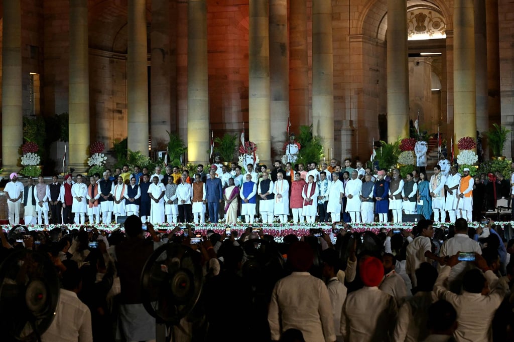 Indias newly sworn-in Prime Minister Narendra Modi (first row, middle, in bright blue) stands for a group photograph with newly sworn-in cabinet ministers after the oath-taking ceremony at the presidential palace in New Delhi. Photo: AFP