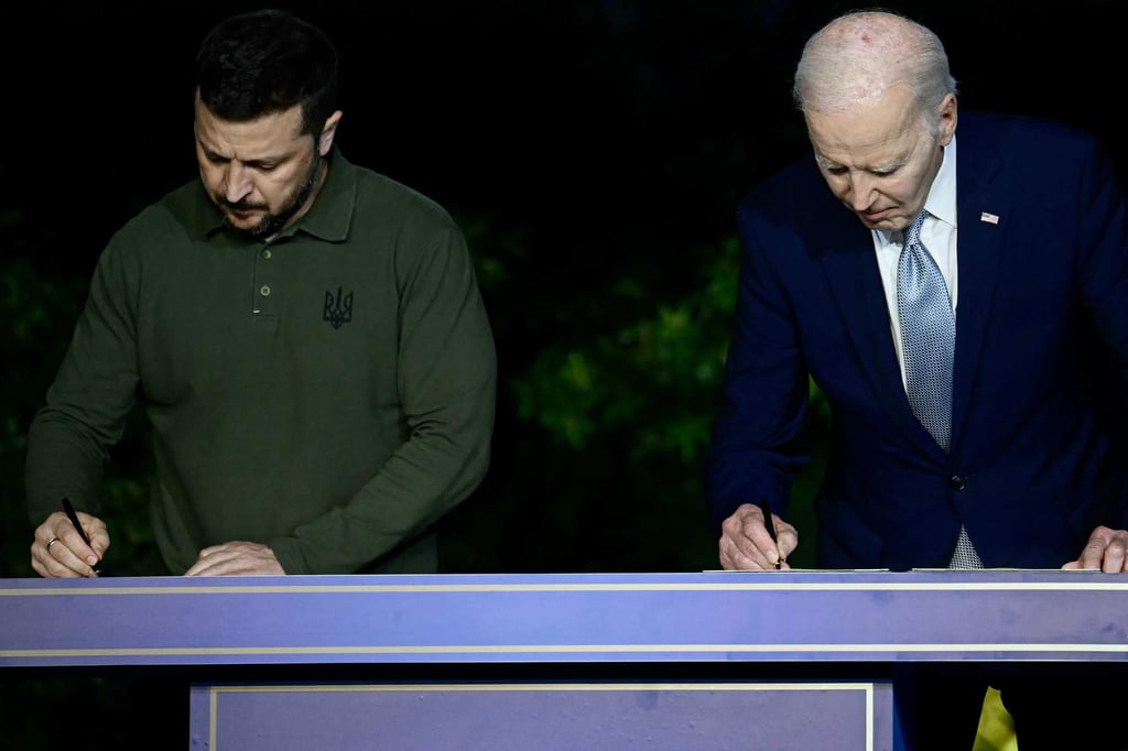 Ukrainian President Volodymyr Zelensky and US President Joe Biden sign the bilateral security agreement. Photo: AFP