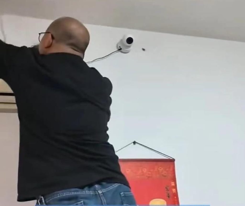 The boy’s father removes the spy camera which had been in place for six years. Photo: 163.com
