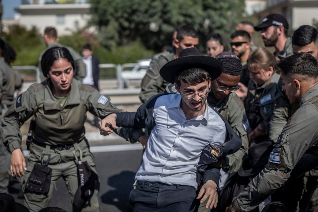 Israeli police officers remove protesters who are blocking a road in Bnei Brak during a protest on June 2 against possible changes in the laws that exempt ultra-Orthodox men from military conscription. Photo: dpa