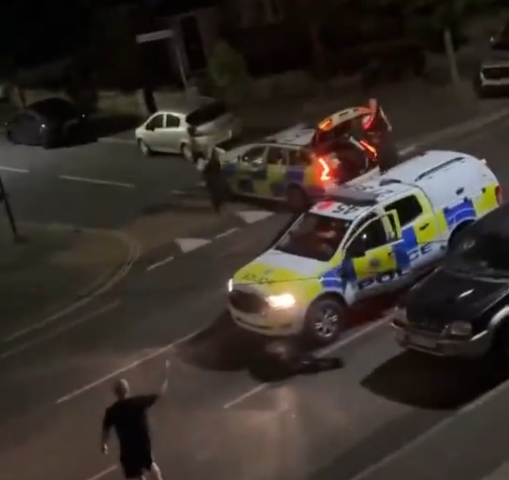 A bystander reacts after a cow was hit by a police car in Staines-upon-Thames, just outside London, on Thursday. Photo: X/UB1UB2