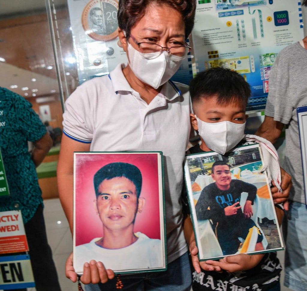 Mary Ann Domingo and her son hold portraits of her husband and son after four policemen were found guilty of killing them during their trial at a court in Manila on Tuesday. Photo: AFP Mary Ann Domingo and her son hold portraits of her husband and son after four policemen were found guilty of killing them during their trial at a court in Manila on Tuesday. Photo: AFP