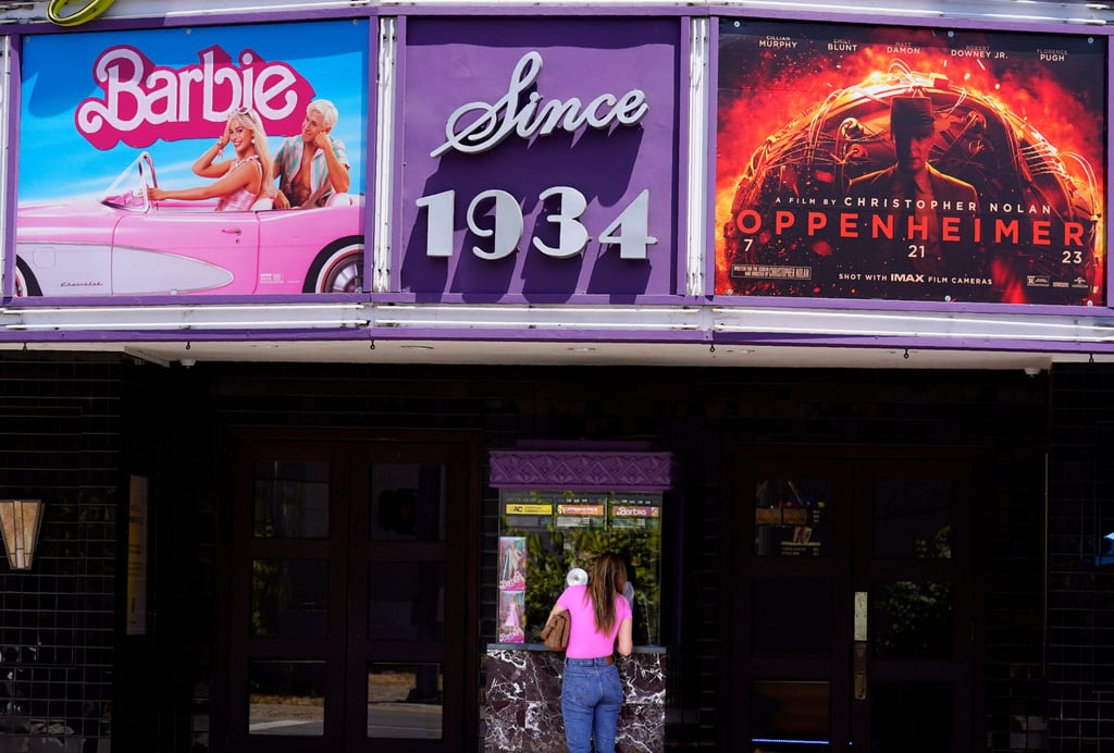 A patron buys a ticket beneath a marquee promoting the films Barbie and Oppenheimer in Los Angeles in 2023. For every “Barbenheimer” success story, there has been a film that has failed to meet its projected return. Photo: AP