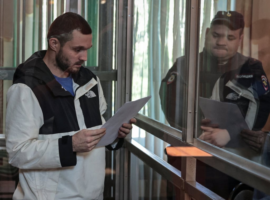 Gordon Black reads documents inside a glass cage in the court. Photo: Reuters Gordon Black reads documents inside a glass cage in the court. Photo: Reuters
