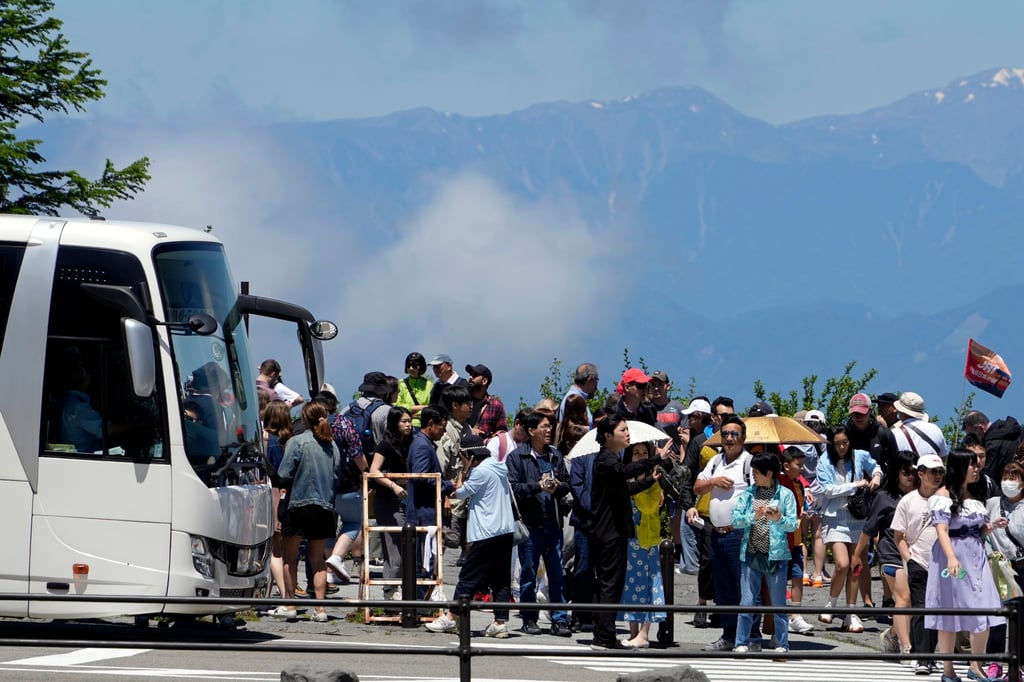 Tourists gather near a bus at Mount Fuji 5th station in Yamanashi prefecture. Photo: EPA-EFE