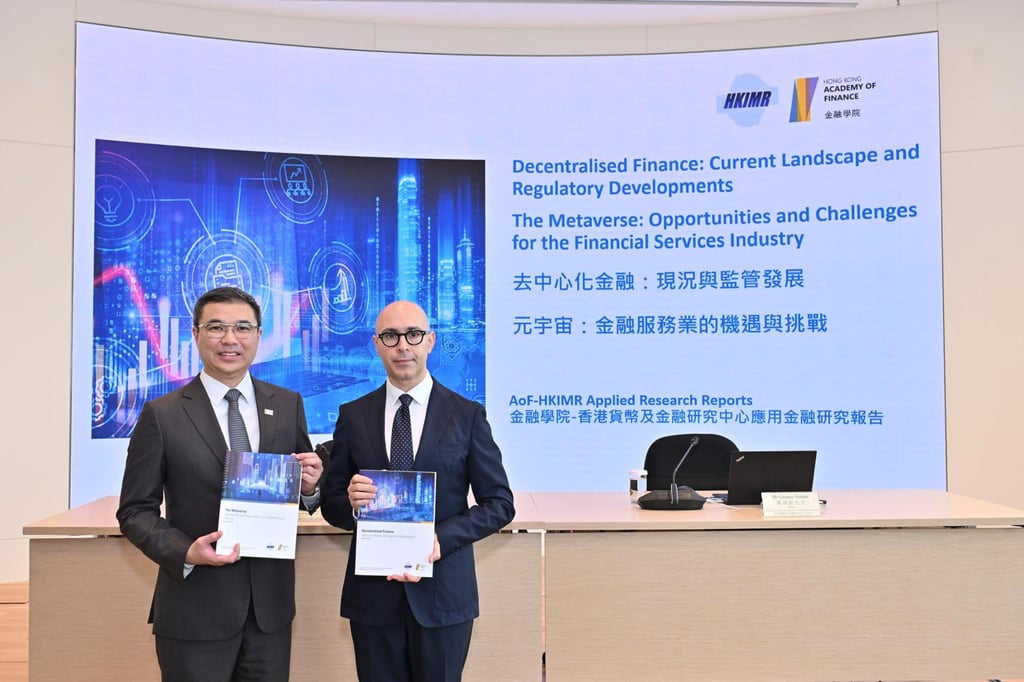 Enoch Fung (left), the executive director of Hong Kong Institute for Monetary and Financial Research, and Giorgio Valente, the head of HKIMR, hold copies of the DeFi and metaverse surveys on Tuesday. Photo: HKIMR