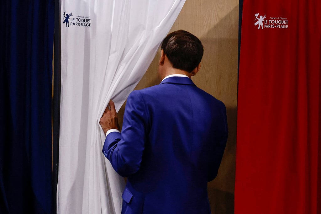 French President Emmanuel Macron entering a voting booth on Sunday. Photo: Reuters