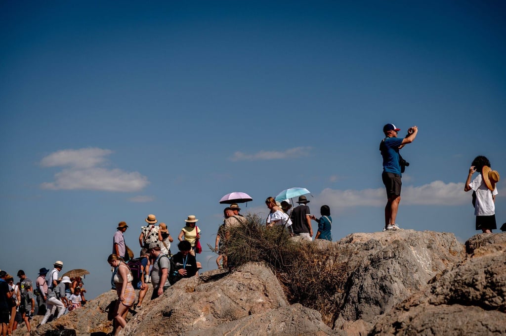 Tourists take photos of the ancient Acropolis in Athens, Greece. Private group visits will be held outside normal opening hours. Photo: Bloomberg
