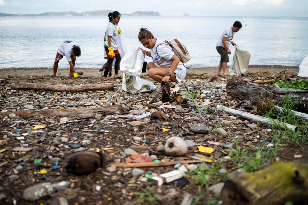 People collect plastic waste on a beach in Mabini, Batangas province, Philippines. Photo: Reuters People collect plastic waste on a beach in Mabini, Batangas province, Philippines. Photo: Reuters