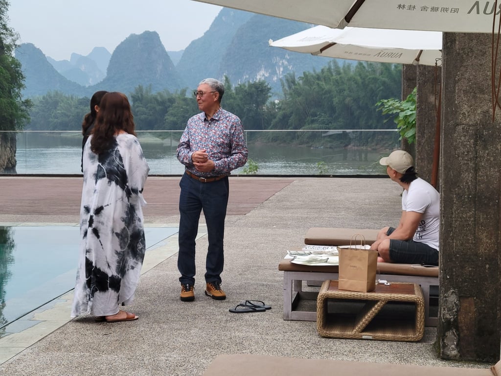 Danny T.T. Chan (centre) by the Sugar House pool. Artist Hu Xingyi, seated on the right, is in the process of capturing the Li River in a watercolour. Photo: Kristian Odebjer Danny T.T. Chan (centre) by the Sugar House pool. Artist Hu Xingyi, seated on the right, is in the process of capturing the Li River in a watercolour. Photo: Kristian Odebjer