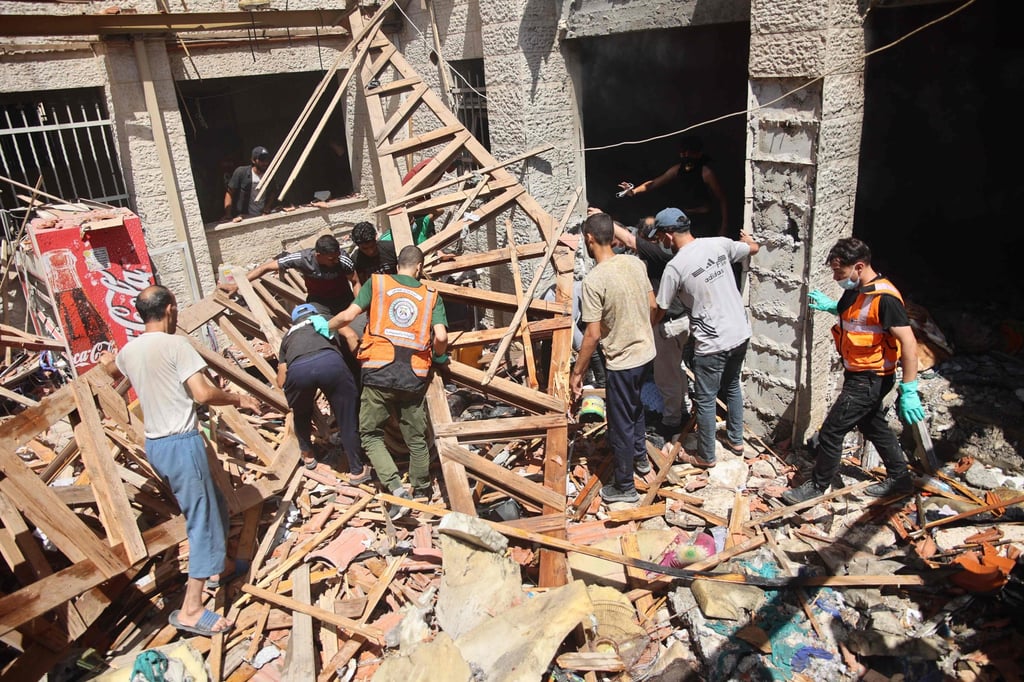 Palestinians rescuers search the rubble of the Latin Patriarchate Holy Family School on Sunday. Photo: AFP