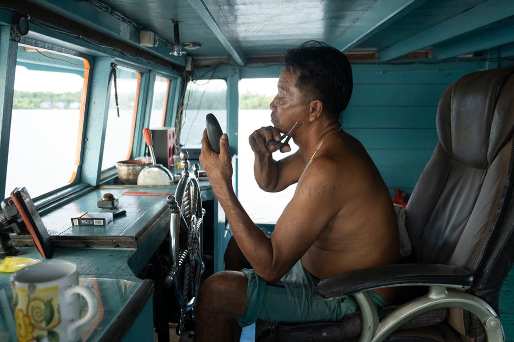 Captain Widarto at the helm of the boat. Photo: Oliver Raw