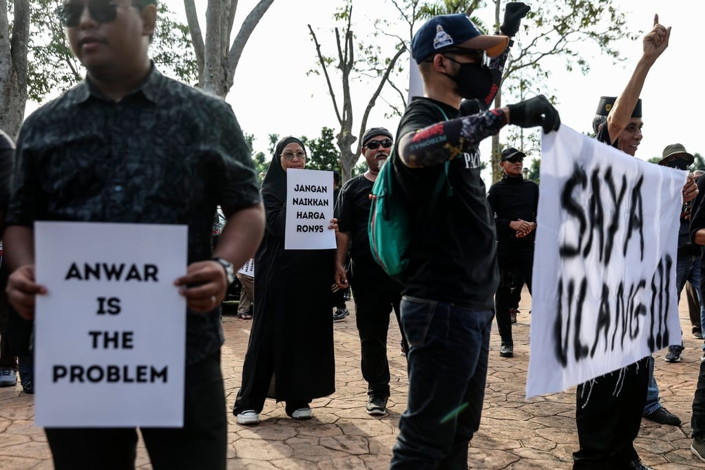 Protesters hold placards outside Malaysian Prime Minister Anwar Ibrahim’s official residence in Putrajaya, during a protest against his administration late last month. Photo: EPA-EFE