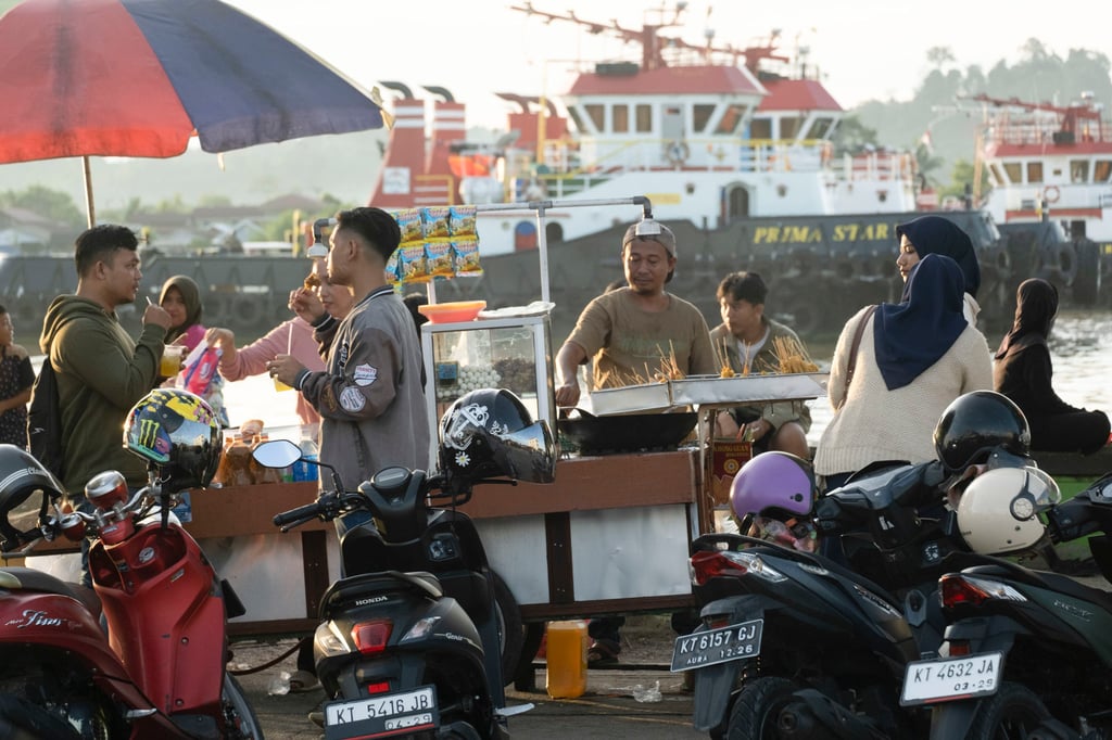 Vendors sell food on the Segai River waterfront. Photo: Oliver Raw