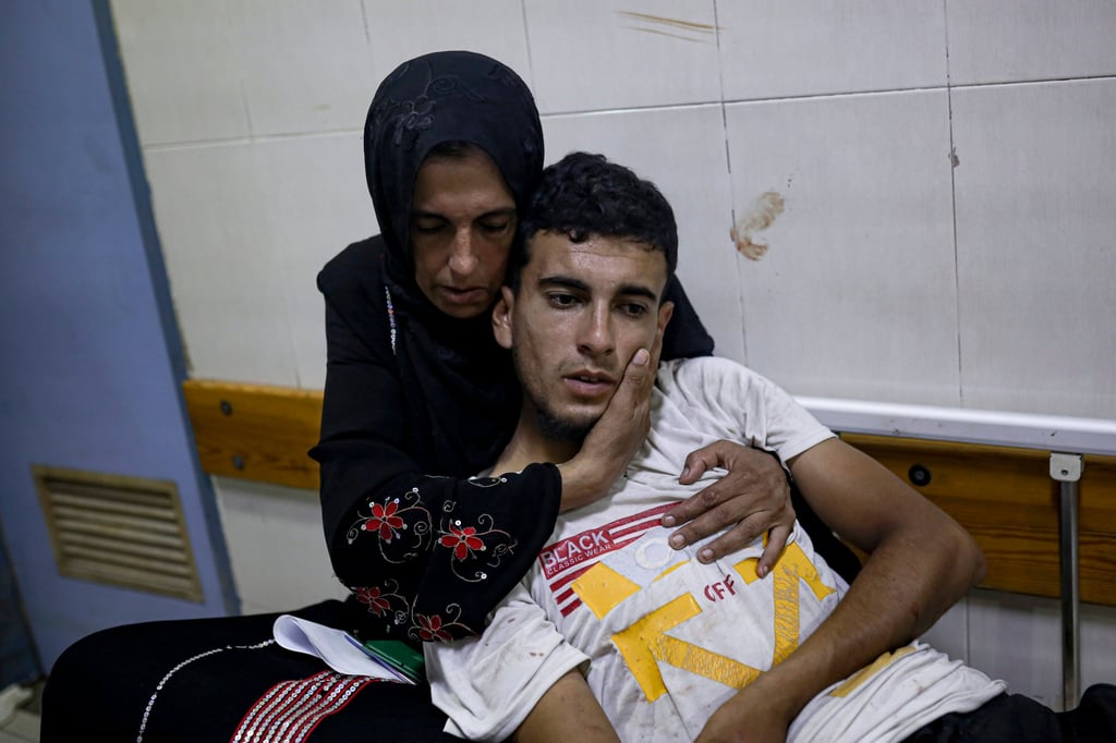 A Palestinian woman hugs her wounded son. Photo: AP A Palestinian woman hugs her wounded son. Photo: AP
