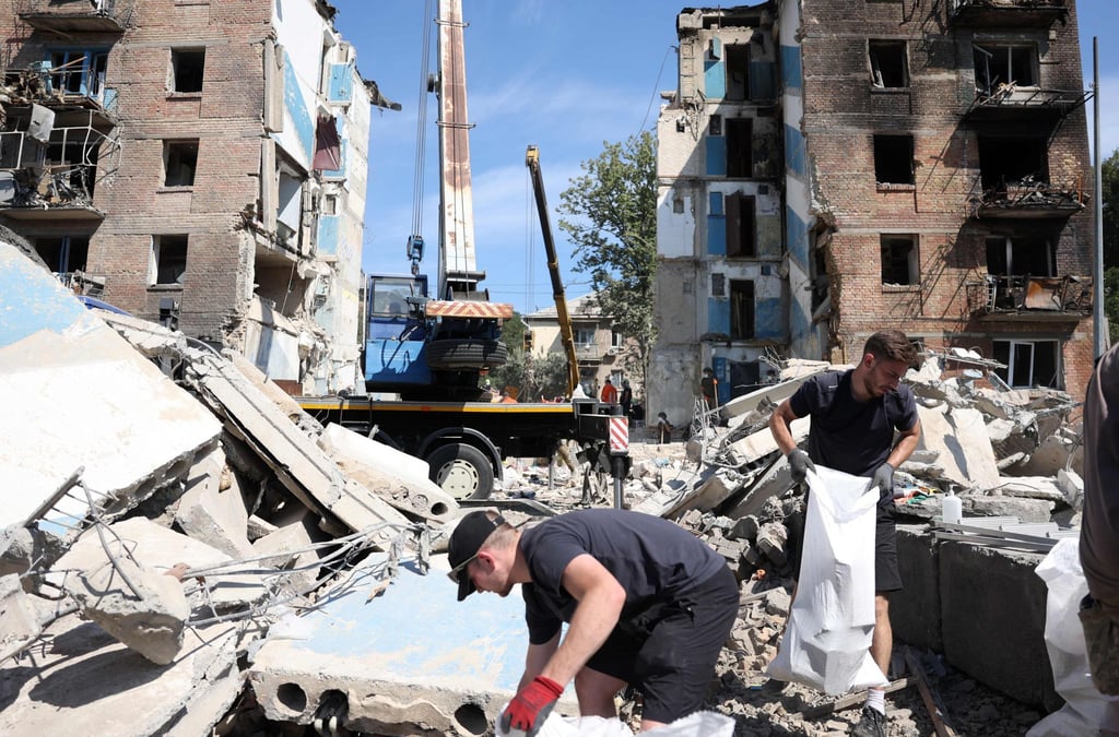 Volunteers on Tuesday clear the rubble of a destroyed building following a rocket attack in Kyiv on Monday. Photo: AFP