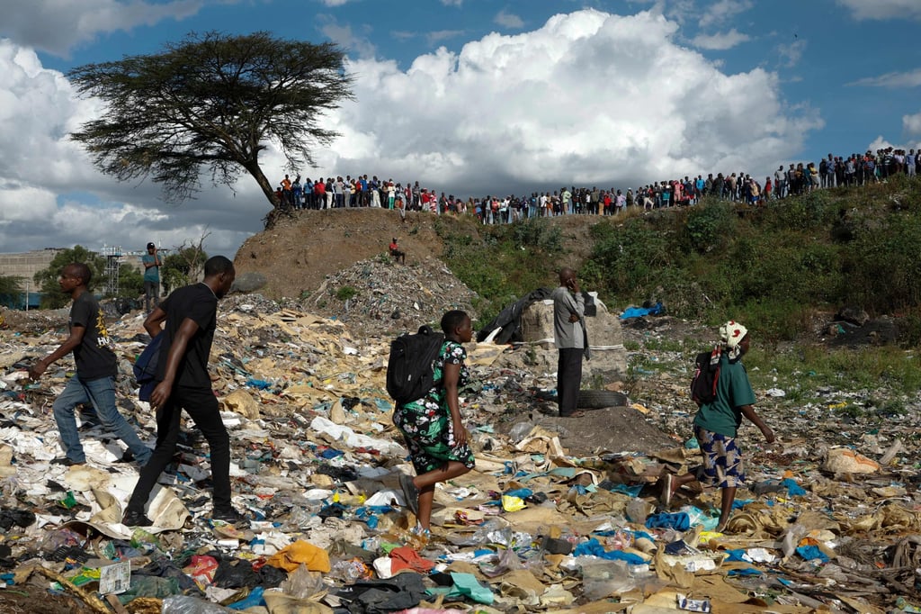 People walk on a sea of rubbish as others stand on the edge of a dumpsite where multiple bodies were found at the landfill in Nairobi’s Mukuru slum on Friday. Photo: AFP People walk on a sea of rubbish as others stand on the edge of a dumpsite where multiple bodies were found at the landfill in Nairobi’s Mukuru slum on Friday. Photo: AFP