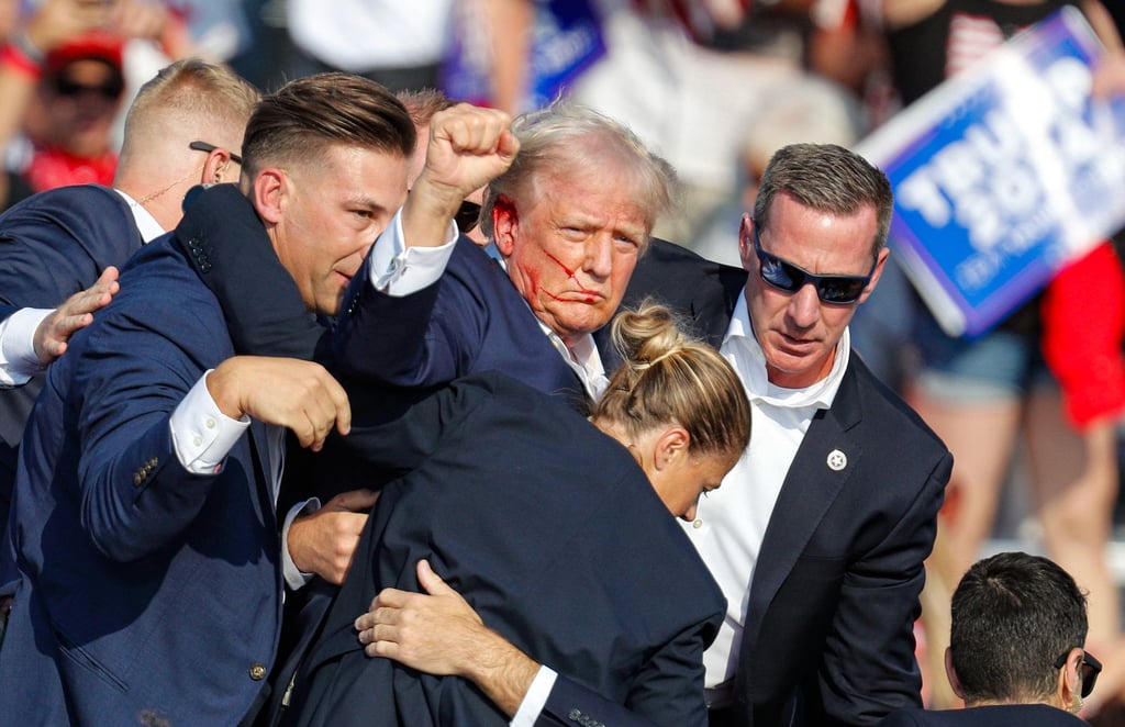 A defiant Donald Trump is rushed offstage by secret service following the shooting at a campaign rally in Pennsylvania. Photo: EPA-EFE