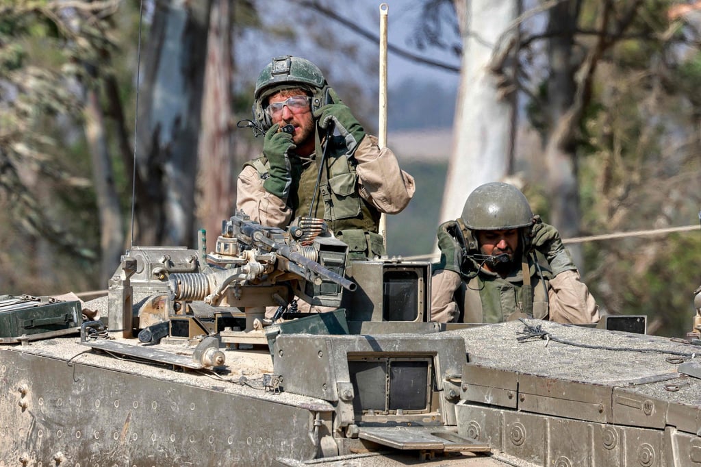 Israeli soldiers in a battle tank at a position along the border with Gaza and southern Israel on Sunday. Photo: AFP