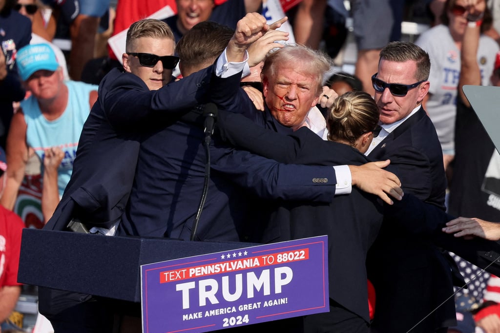 Donald Trump gestures with a bloodied face after he was shot in the right ear during a campaign rally in Butler, Pennsylvania on Saturday. Photo: Reuters Donald Trump gestures with a bloodied face after he was shot in the right ear during a campaign rally in Butler, Pennsylvania on Saturday. Photo: Reuters
