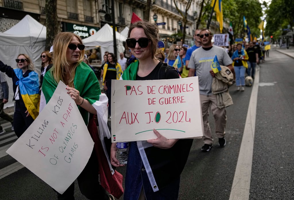 Ukrainian supporters hold banners which one reads, “No war criminals at the Olympic Games 2024” in Paris. Photo: AP