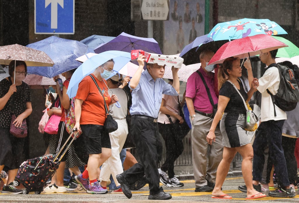 Pedestrians in North Point cross the road in the rain. Photo: Jelly Tse