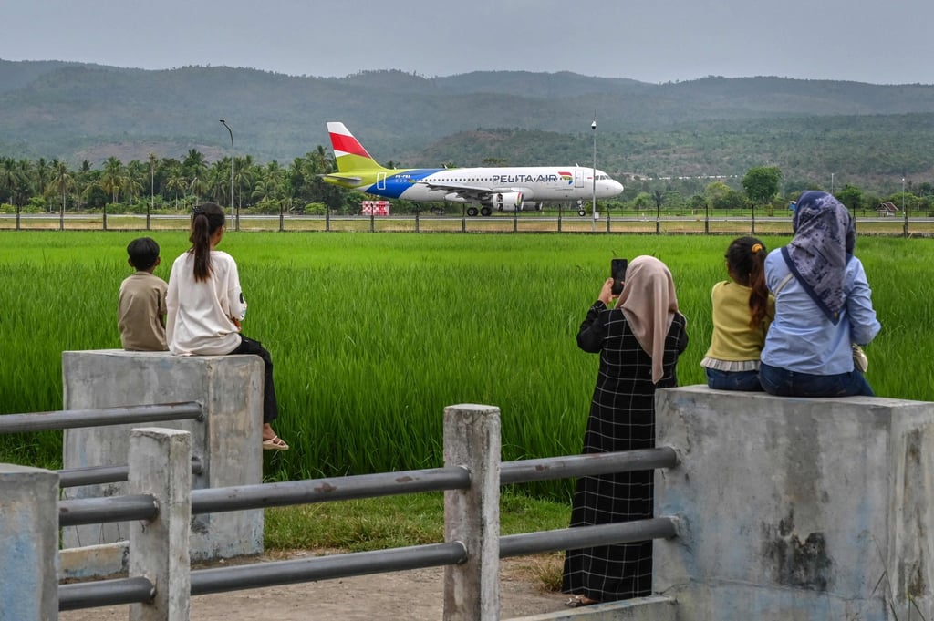 People watch a passenger plane from low-cost Indonesian airline Pelita Air taxi on a runway in Aceh province. Asia is set to lead annual airline passenger growth. Photo. AFP