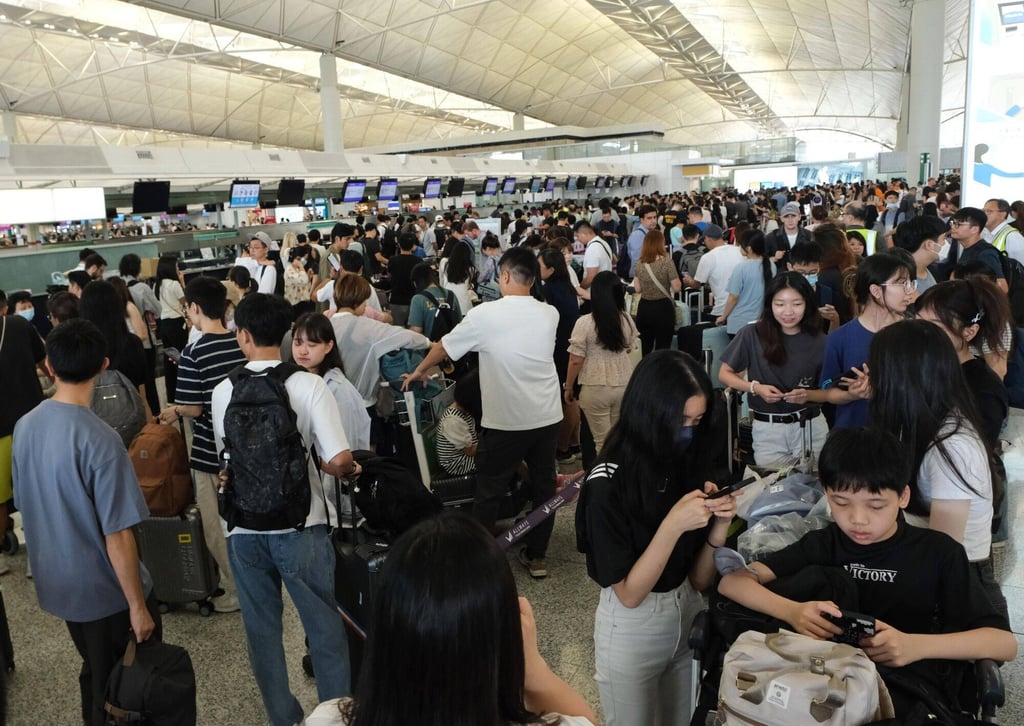 Travelers queue at check-in counters for Hong Kong Express Airways at Hong Kong International Airport on Friday, after a worldwide systems outage. Photo: Bloomberg