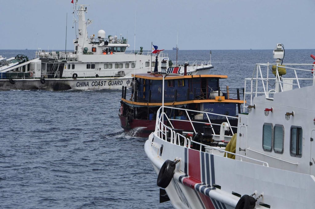 Chinese coastguard ships (left and right) corralling a Philippine civilian boat chartered by the Philippine navy to deliver supplies to the Philippine navy ship BRP Sierra Madre, in disputed waters of the South China Sea in August 2023. Photo: AFP Chinese coastguard ships (left and right) corralling a Philippine civilian boat chartered by the Philippine navy to deliver supplies to the Philippine navy ship BRP Sierra Madre, in disputed waters of the South China Sea in August 2023. Photo: AFP