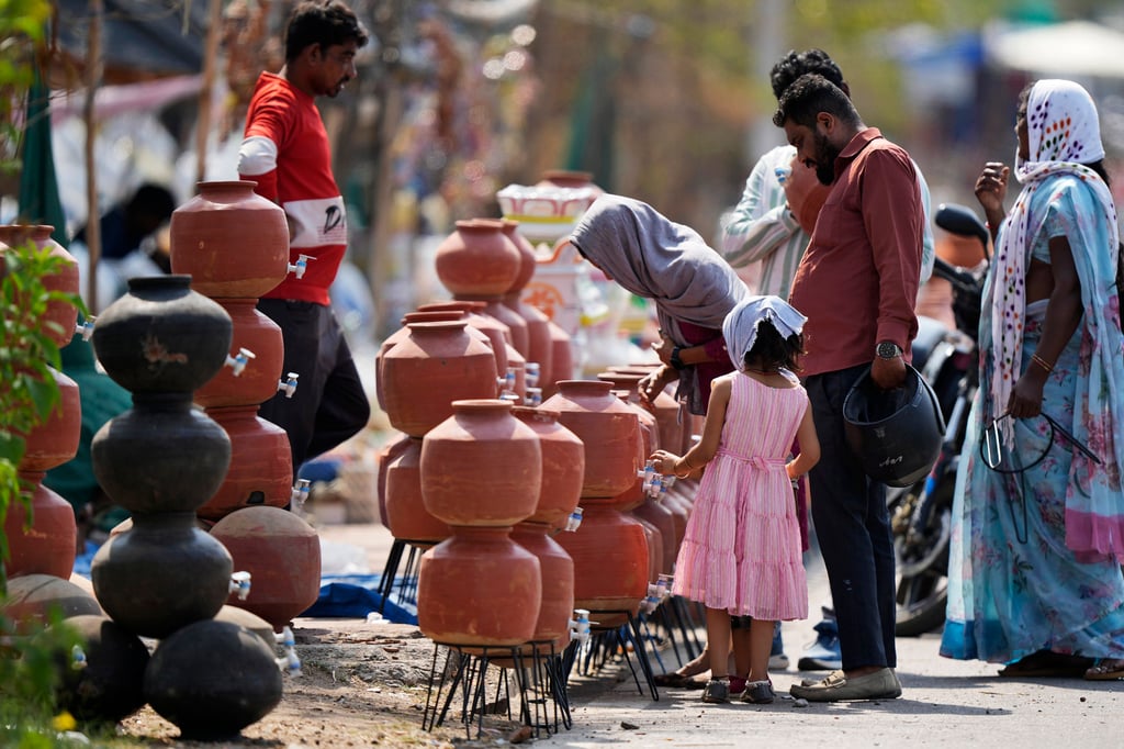 People shop for earthen water vessels, known locally as a poor man’s refrigerator, from a roadside vendor in Hyderabad, India, in May. Photo: AP