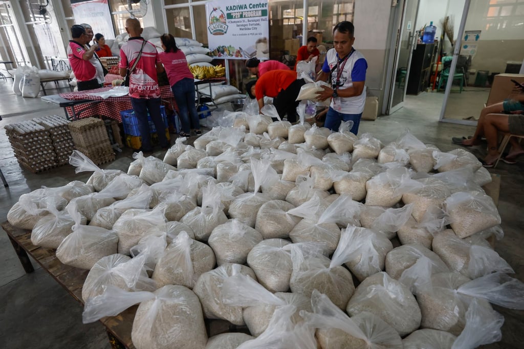 A worker stacks bags of rice at a village market in Metro Manila. Critics say President Ferdinand Marcos Jnr failed to mention a campaign promise to bring down rice prices in the Philippines. Photo: EPA-EFE