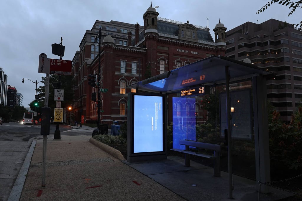 A blue Windows error message caused by the CrowdStrike software update is displayed on a screen in a bus shelter on July 22, 2024 in Washington, DC. Photo: Getty Images via AFP